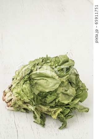 unhealthy bunch of lettuce getting rotten on table 65911751