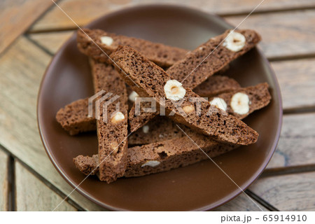 chocolate Homemade biscotti with nuts on a brown plate on a wooden table 65914910