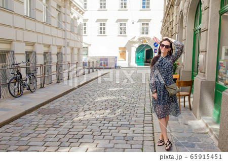 Woman walking in city. Young attractive tourist outdoors in italian city Woman walking in city. Young attractive tourist outdoors in italian city 65915451