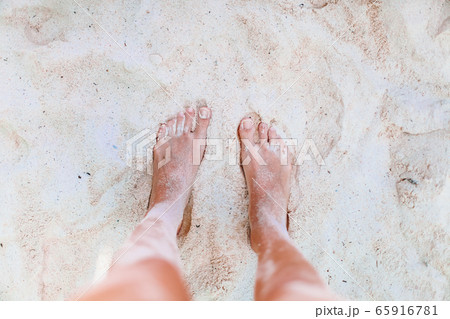 Young woman sunbathing on white beach. Legs. Young woman sunbathing on white beach. Legs. 65916781