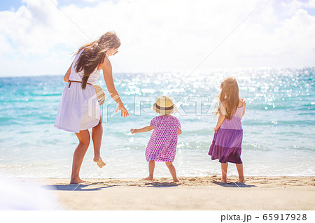 Adorable little girls and young mother on tropical white beach Adorable little girls and young mother on tropical white beach 65917928