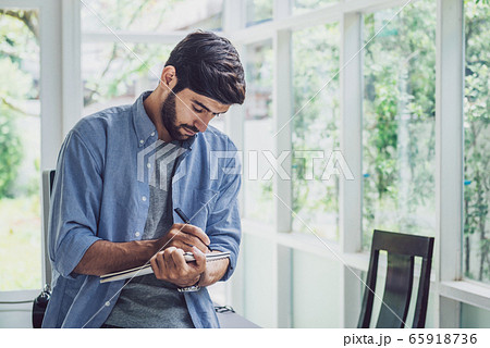 A man looking and thinking at note book while A man looking and thinking at note book while 65918736