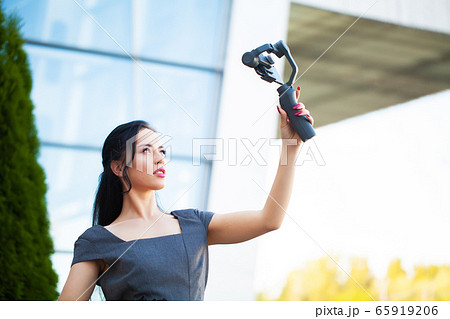 Blogger girl shoots a video about traveling on an electronic stabilizer. Blogger girl shoots a video about traveling on an electronic stabilizer. 65919206