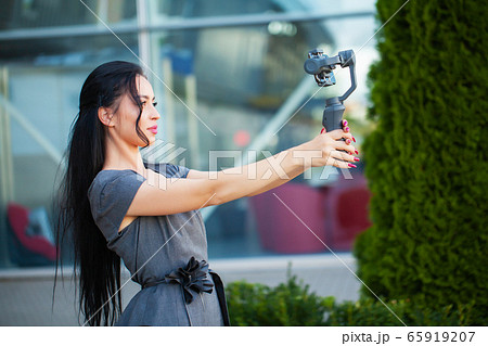 Blogger girl shoots a video about traveling on an electronic stabilizer. 65919207