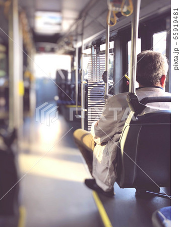 a man sitting in an empty public bus a man sitting in an empty public bus 65919481