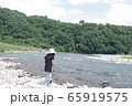 河岸で何かを見つけた帽子をかぶった女の子 65919575