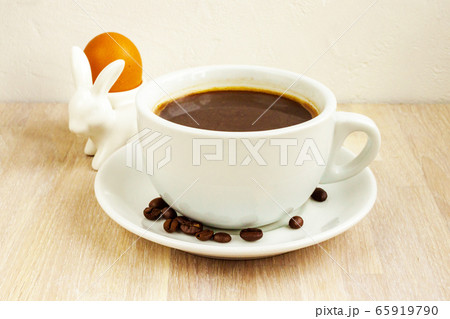 Coffee cup, saucer, beans, rabbit egg holder. Easter breakfast concept 65919790