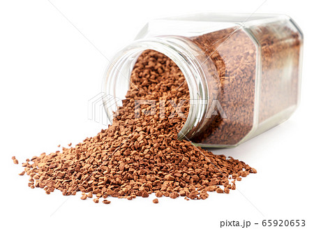 Instant coffee spills out of a glass jar on a 65920653