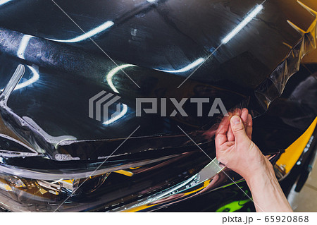 Transparent film, car paint protection, wrapping specialis. Car detailing. Selective focus. 65920868