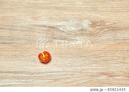 lone half cherry tomato on a wooden table surface lone half cherry tomato on a wooden table surface 65921435