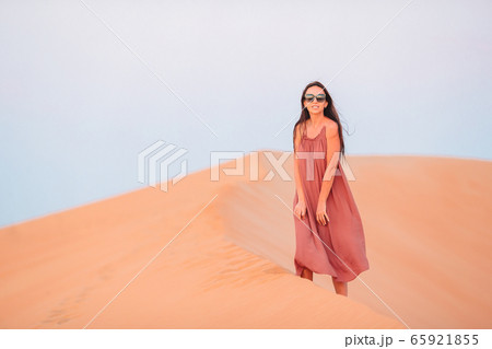 Girl among dunes in desert in United Arab Emirates 65921855