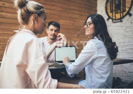 Team of young women and man discussing work questions Team of young women and man discussing work questions 65922431