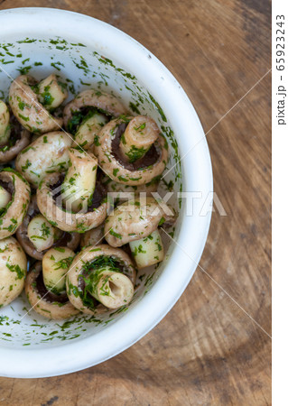 in a bowl raw mushrooms champignons in a marinade with herbs, dill in a rustic natural form. View 65923243