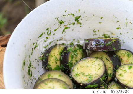 in a bowl, raw, struck eggplant in a marinade with herbs, dill in a rustic natural form. Preparation 65923280