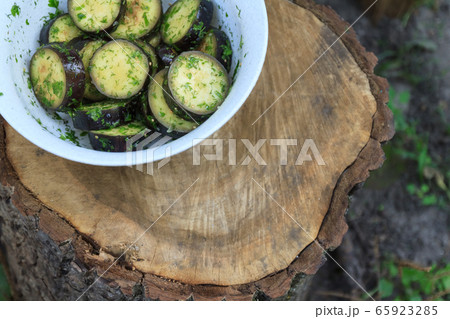 in a bowl, raw, struck eggplant in a marinade with herbs, dill in a rustic natural form. Preparation 65923285