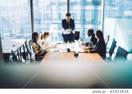 Displeased boss talking with employees during meeting 65923626