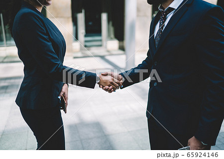 Elegant coworkers greeting each other n street 65924146