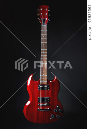 red electric guitar on dark gray background 65925565