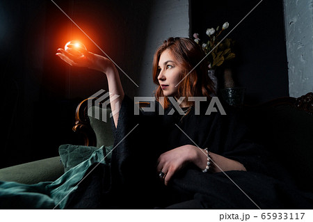 Woman in black suit holding crystal ball Woman in black suit holding crystal ball 65933117