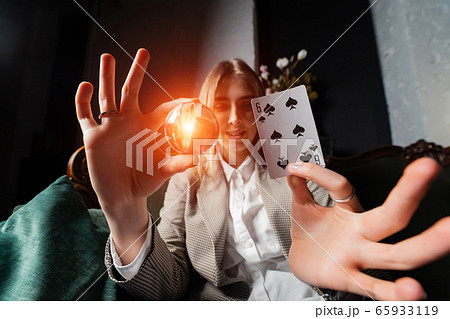 Woman in business suit holding crystal ball and six spade Woman in business suit holding crystal ball and six spade 65933119