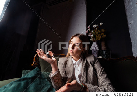 Woman in business suit holding crystal ball Woman in business suit holding crystal ball 65933121