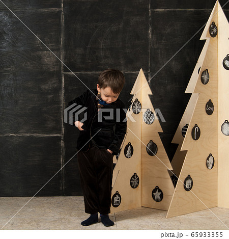the little boy next to decorative Christmas trees 65933355