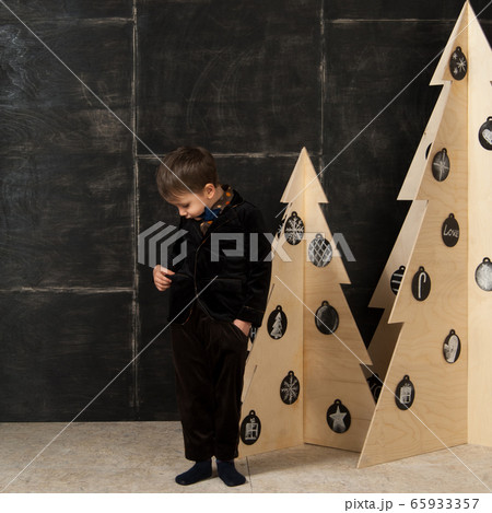 the little boy next to decorative Christmas trees 65933357
