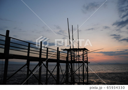 有明海に沈む夕日と古式漁法くもで網漁 有明海に沈む夕日と古式漁法くもで網漁 65934330