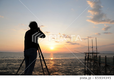 有明海に沈む夕日を撮影するカメラマン 有明海に沈む夕日を撮影するカメラマン 65934345