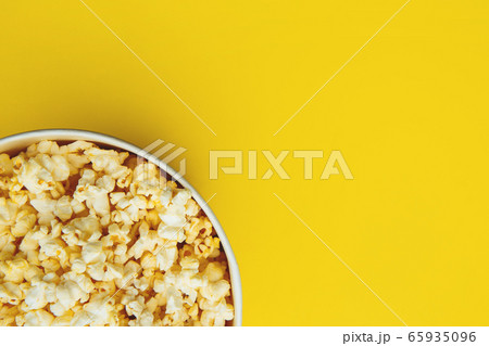 Popcorn closeup viewed from above on yellow background. Flat lay of pop corn bowl. Top view Popcorn closeup viewed from above on yellow background. Flat lay of pop corn bowl. Top view 65935096