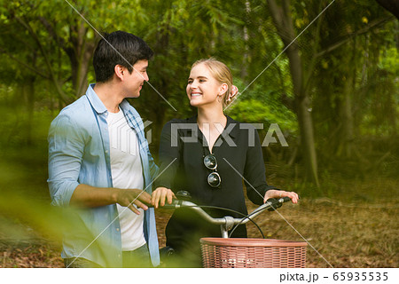 Happy young couple going for a bike ride on a 65935535