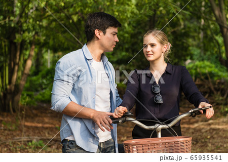 Happy young couple going for a bike ride on a 65935541