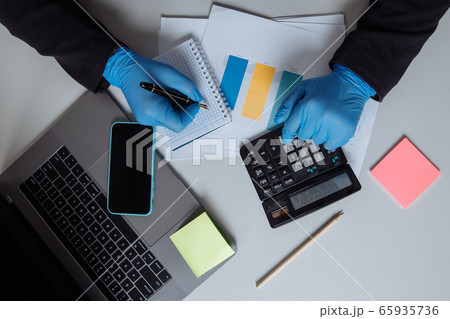Businessman working on office desk. Working with laptop and calculator making a note something of idea. Top view 65935736