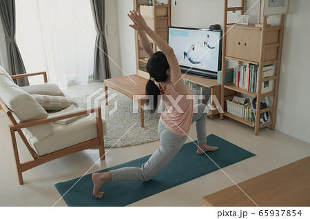 家で動画を見ながらヨガをする女性　おうちヨガ　家でヨガをする女性　 65937854