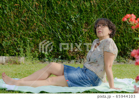 mature woman is resting in the garden 65944103