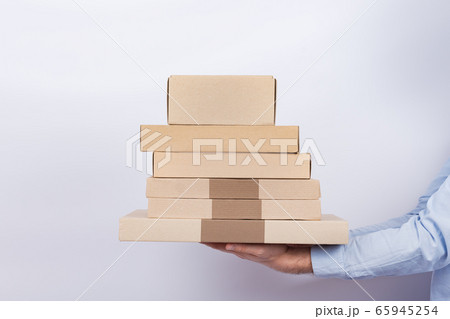 Delivery man holding cardboard boxes on white Delivery man holding cardboard boxes on white 65945254