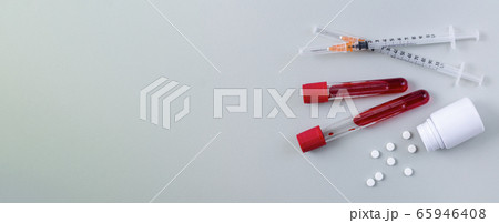 Medical banner with blood samples test tube, syringes and white tablets on light gray background top view Medical banner with blood samples test tube, syringes and white tablets on light gray background top view 65946408