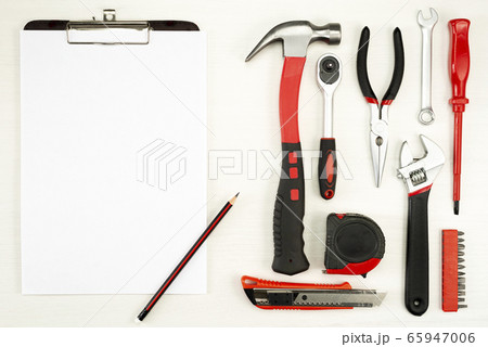 large set of construction tools with a sheet of white paper with a pencil on a white background, top view 65947006