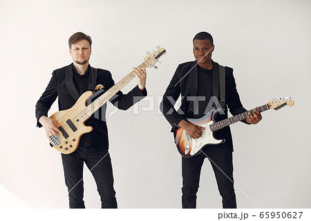 Man in black suit standing with a guitar Man in black suit standing with a guitar 65950627