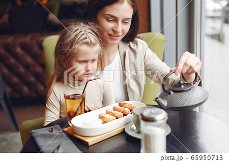 Mother with daughter sitting in a cafe 65950713