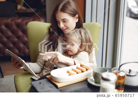 Mother with daughter sitting in a cafe Mother with daughter sitting in a cafe 65950717