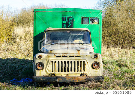 front view of an old, abandoned truck in a meadow 65951089