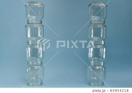 Two vertical parallel rows of glass jars on a blue background. 65954218