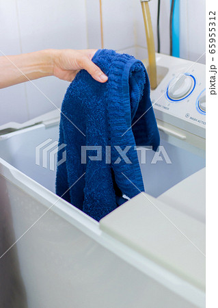 She put the clothes into the washing machine. She put the clothes into the washing machine. 65955312