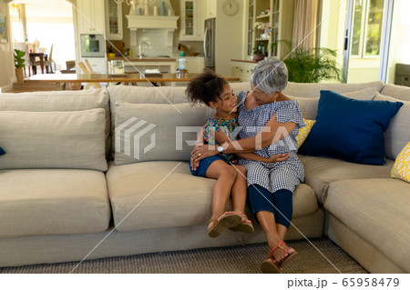 Senior mixed race woman with her granddaughter at home 65958479