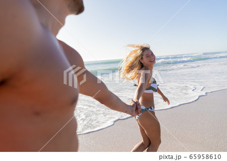 Caucasian couple walking at the beach 65958610