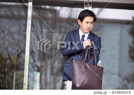 忘れ物がないかバッグを確認して出勤するアジア人ビジネスマン 65960659