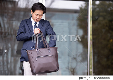 忘れ物がないかバッグを確認して出勤するアジア人ビジネスマン 65960660