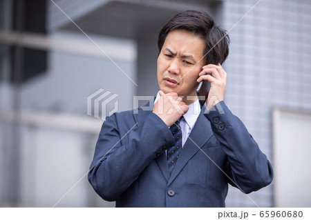 スマホで電話しながら困るビジネスマン（トラブル） 65960680