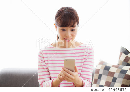 女性　スマホ　携帯　リビング　ひとり暮らし 65963632